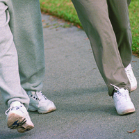 lower body shot, two people walking in tennis shoes